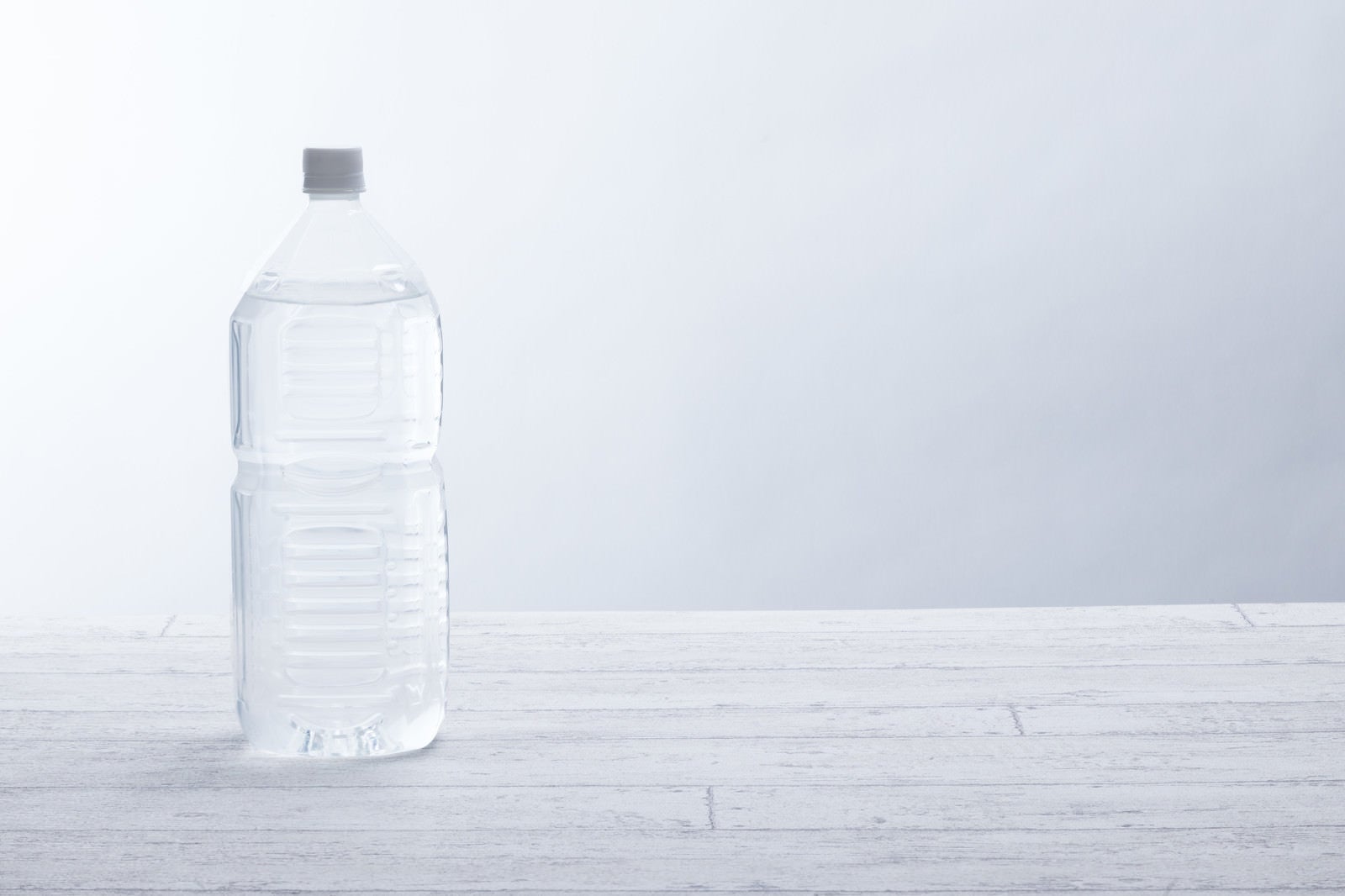 水を入った透明なペットボトルは、川と滝の背景に木製の幹に立っています。純粋な天然飲料水の概念の写真素材・画像素材 Image 129140815