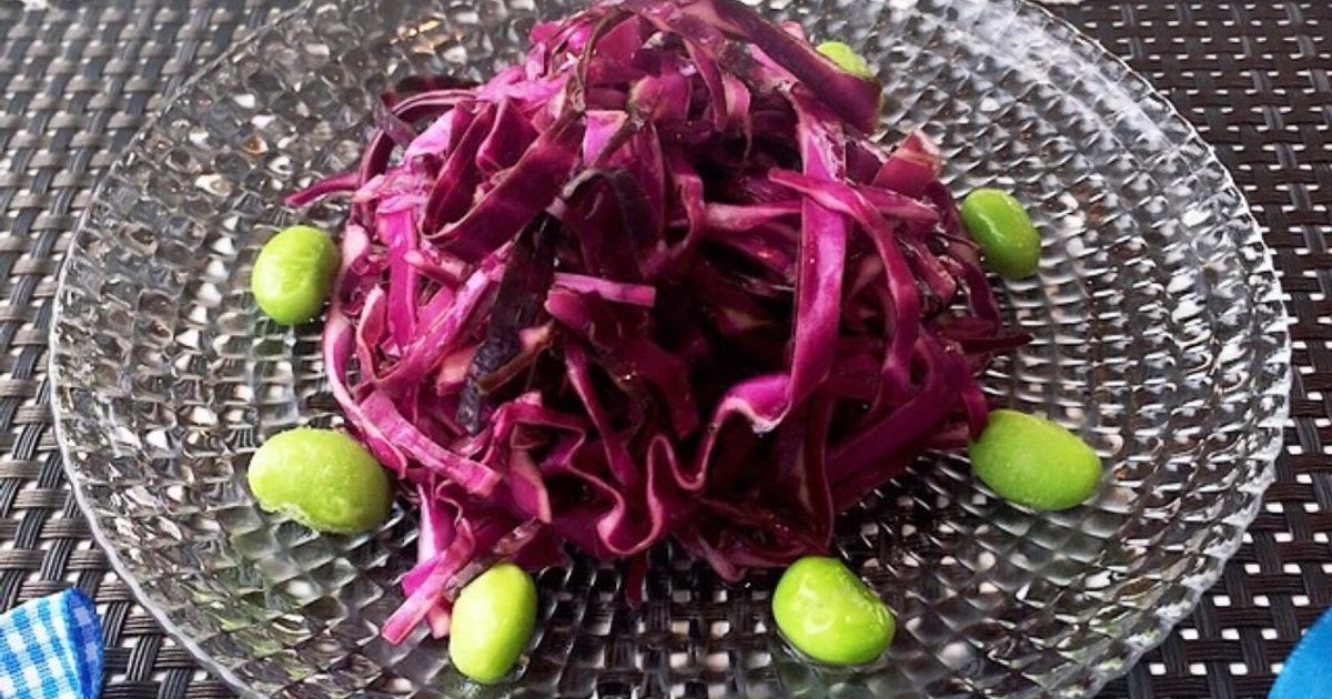 スーパーのカット野菜や食堂のサラダなんかは薄めたハイターに漬けて殺菌するんですよ。 もちろんその後流水でしっかりすすぎますが、ハイターはアルカリ性なので 紫キャベツの色素であるアントシアニンが反応した色でしょうね