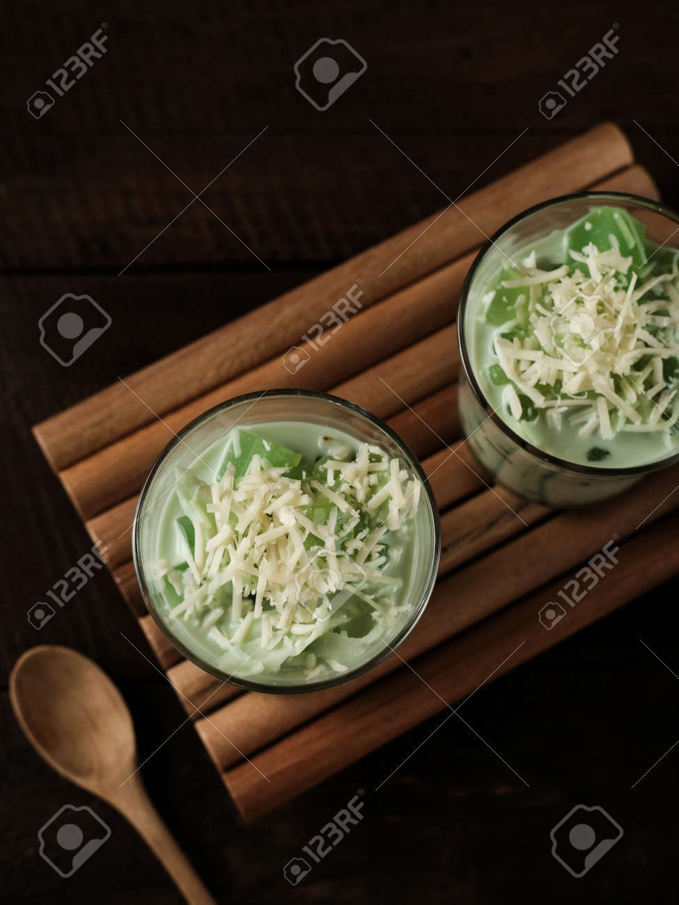 ブコパンダンは、ゼリーとパンダンジュースにサゴパールと細かく刻んだココナッツの果肉をクリームまたはミルクで混ぜた甘い食べ物です。コピースペースのあるガラスの白いテーブルの背景に添えて。Premium写真