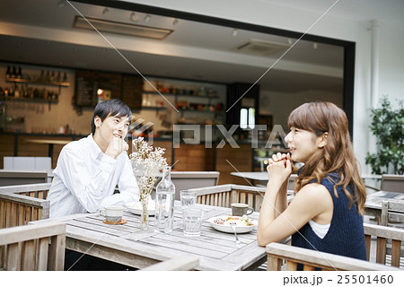 椅子に座り、お互いに抱き合い、カフェやレストランでつるを飲む。カフェで男女2人がコミュニケーションを取り、笑いながらお互いに過ごす時間を楽しんでいます。デートで恋に落ちたカップルラブストーリーとバレンタインデーのコンセプトの写真素材・画像素材Image 94424259