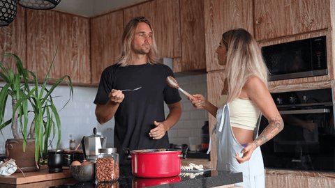 カップルが一緒に料理をしながら料理を試飲無料写真