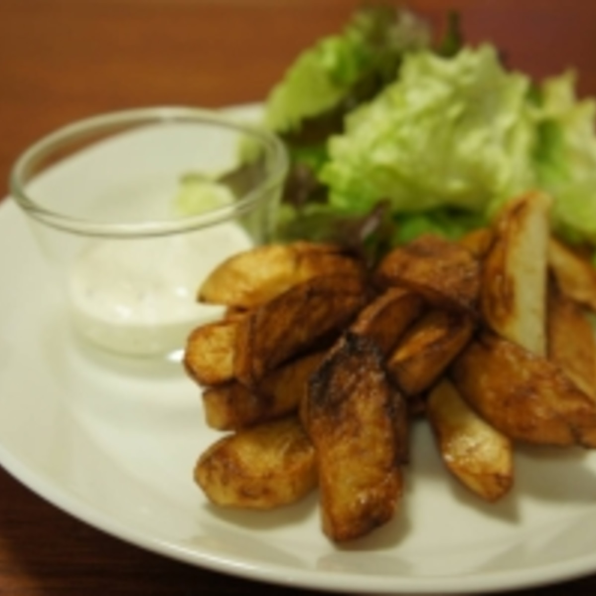 木箱に入ったフライドポテトにとろけるチーズソースを注ぐ男性Premium写真