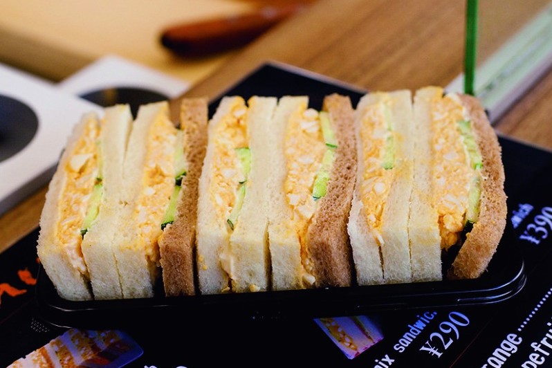 今日のお昼は、京都駅新幹線上りホームのサンドイッチ屋さんで買い求めた「カツサンド」「ミックスサンド 」 いずれもハーフ と、サントリー「贅沢微糖コーヒー」でした。ここのサンドイッチ屋さんは現場で作られており、新鮮かつ美味しいことで定評があります。私は大体