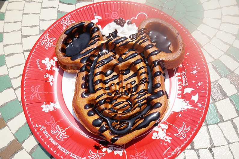 朝一で食べたミッキーワッフル🐭🧇 背景は青空×ピンクのパラソルでイベントのテーマカラーにしてみました🩷🩵 ⁡レモンピール入りのホイップがとっても美味しかったです😋🍋 ピンクのハート付きでいつになくキュートな雰囲気のミッキーワッフルでした☺️🩷 ⁡ミニー